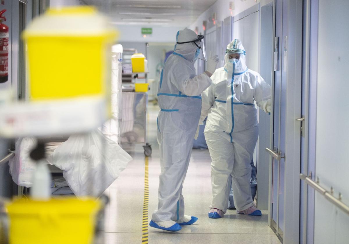 Dos sanitarios protegidos con trajes especiales comprueban el estado de los pacientes aislados durante las primeras semanas de la pandemia en el hospital Reina Sofía de Murcia.