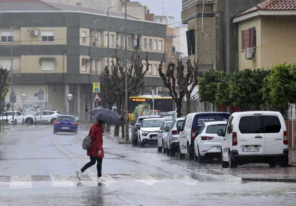 Una mujer cruza por un paso de peatones, este viernes en Murcia, bajo la lluvia.