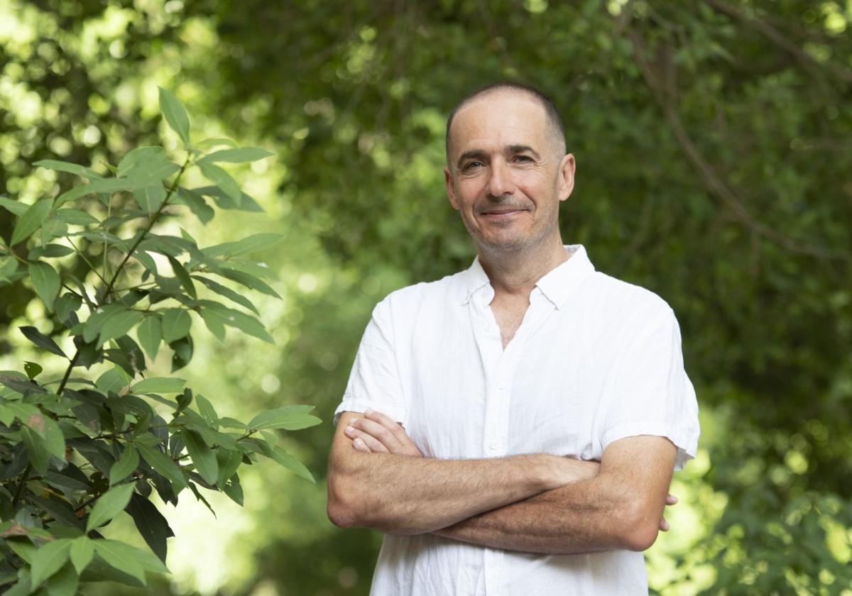 Paco Calvo sonríe en un jardín de la Universidad de Murcia. Portada de 'Planta Sapiens' en su edición en chino.