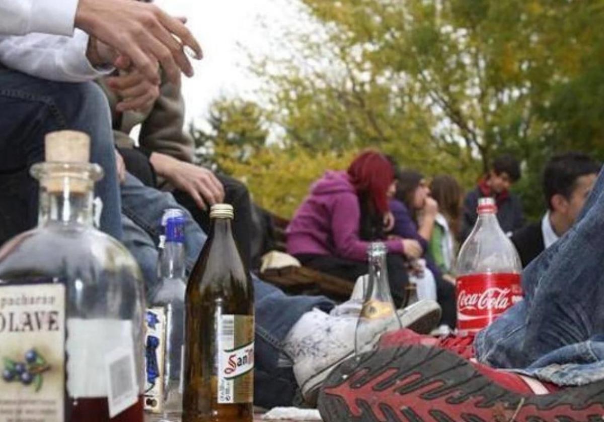 Unos jóvenes consumen bebidas alcohólicas en un parque.