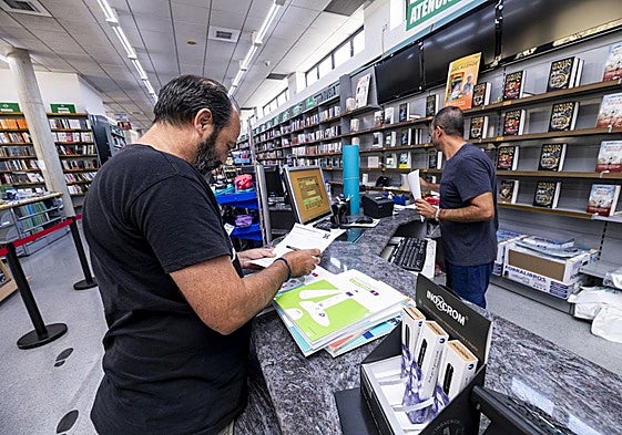 Un hombre compra libros de texto en Murcia.