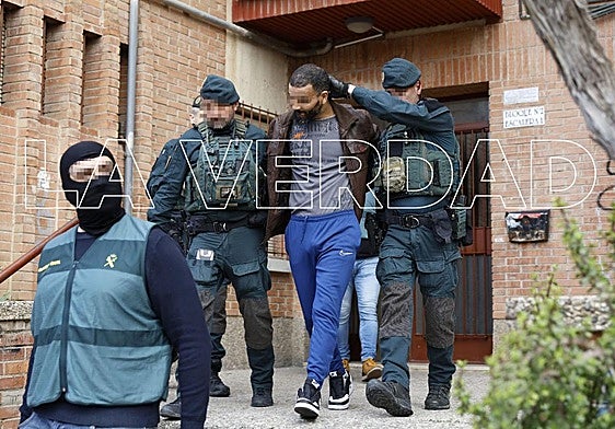 Los agentes, este miércoles, con el presunto yihadista detenido.