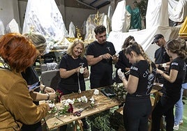 Mujeres, hombres y jóvenes procesionistas participaron en equipo de la siempre laboriosa preparación floral de los tronos.