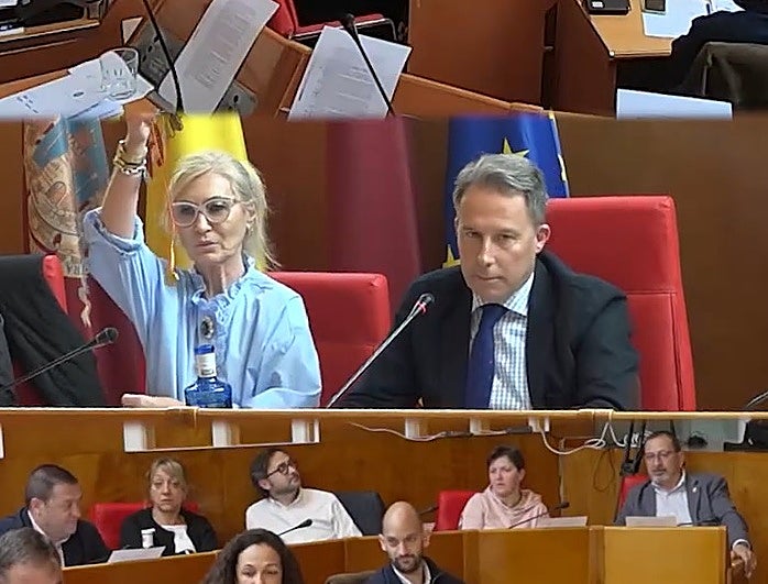 La concejal de Vox Carmen Menduiña muestra la moneda de oro en el Pleno del Ayuntamiento de Lorca.
