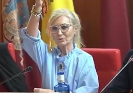 La concejal de Vox Carmen Menduiña muestra la moneda de oro en el Pleno del Ayuntamiento de Lorca.
