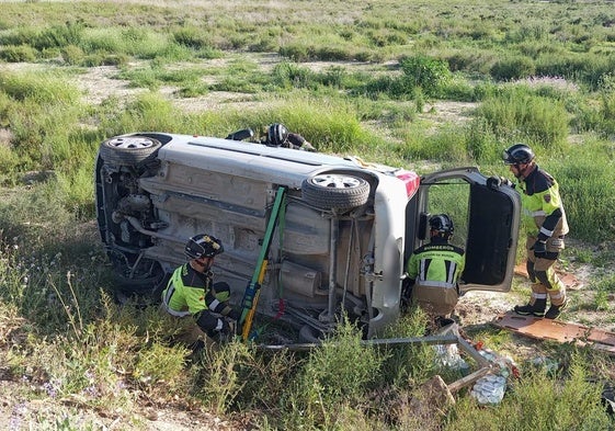Efectivos de bomberos, junto al coche afectado.