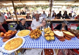 Cocineras de una peña preparan varios platos para ser servidos.