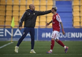 Jesús Cañadas, segundo entrenador del Real Murcia, se acerca a Isi Gómez, que se retira del campo expulsado ante el Alcorcón.