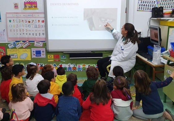 Una enfermera enseña higiene dental a niños en un colegio de Murcia.