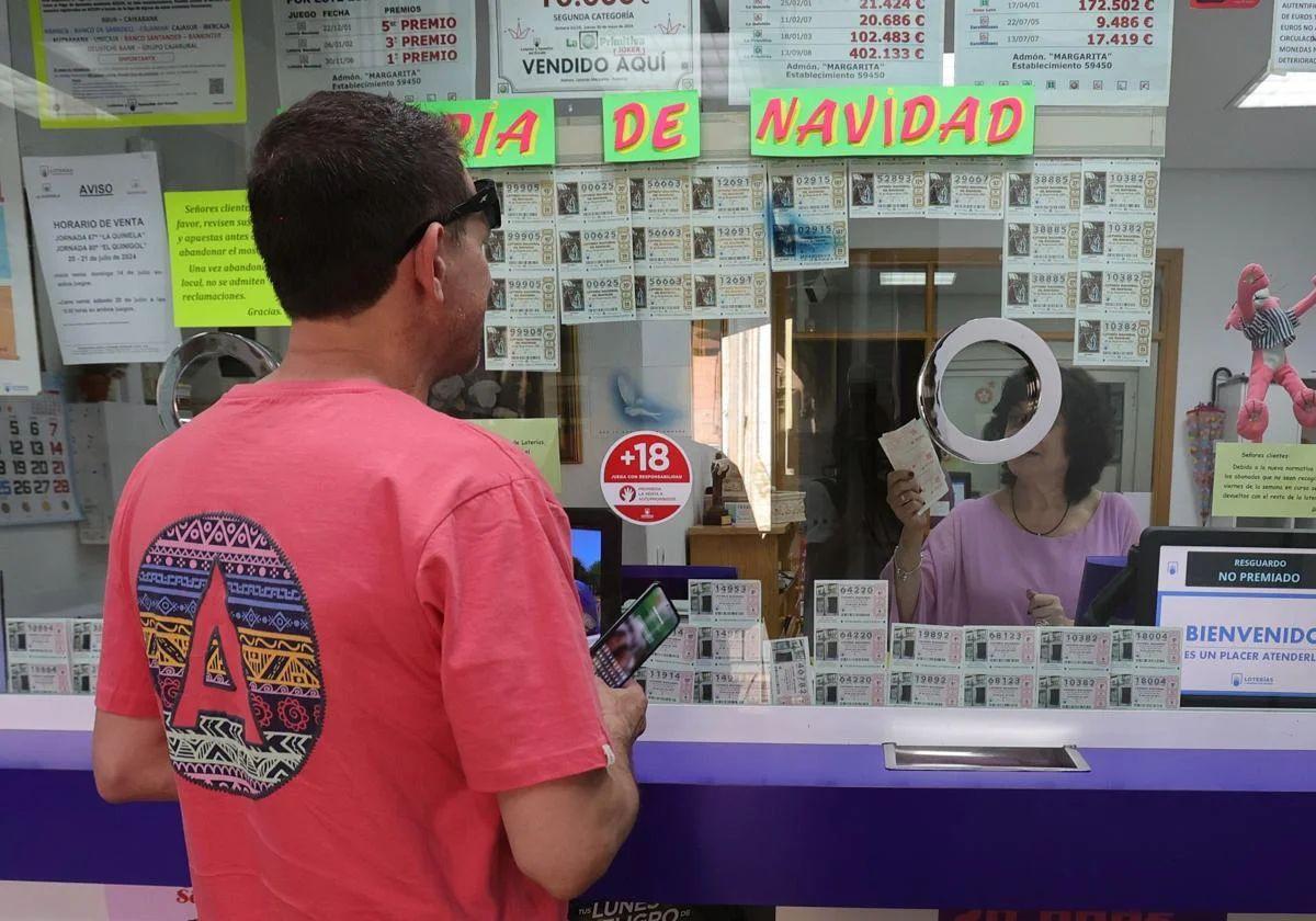 Un hombre compra un décimo del sorteo de la Lotería de Navidad en una administración.