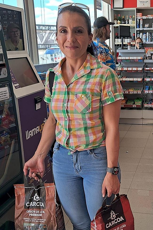 María Isabel Andrade, con dos bolsas de carbón de leña.