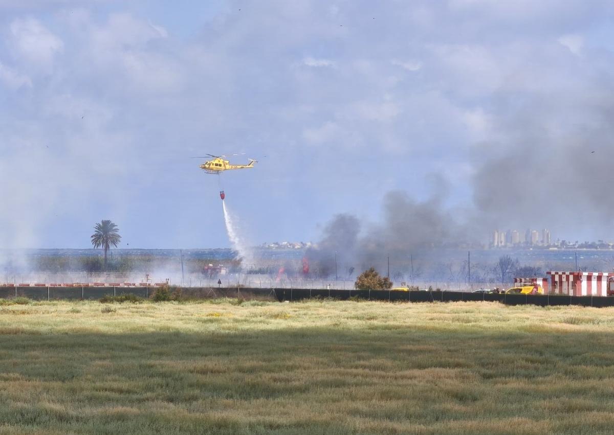 Imagen secundaria 1 - 1. Peter, un residente alemán del camping, señala el humo. 2. Un helicóptero trata de sofocar las llamas. 3. El estado en el que ha quedado la pasarela. 
