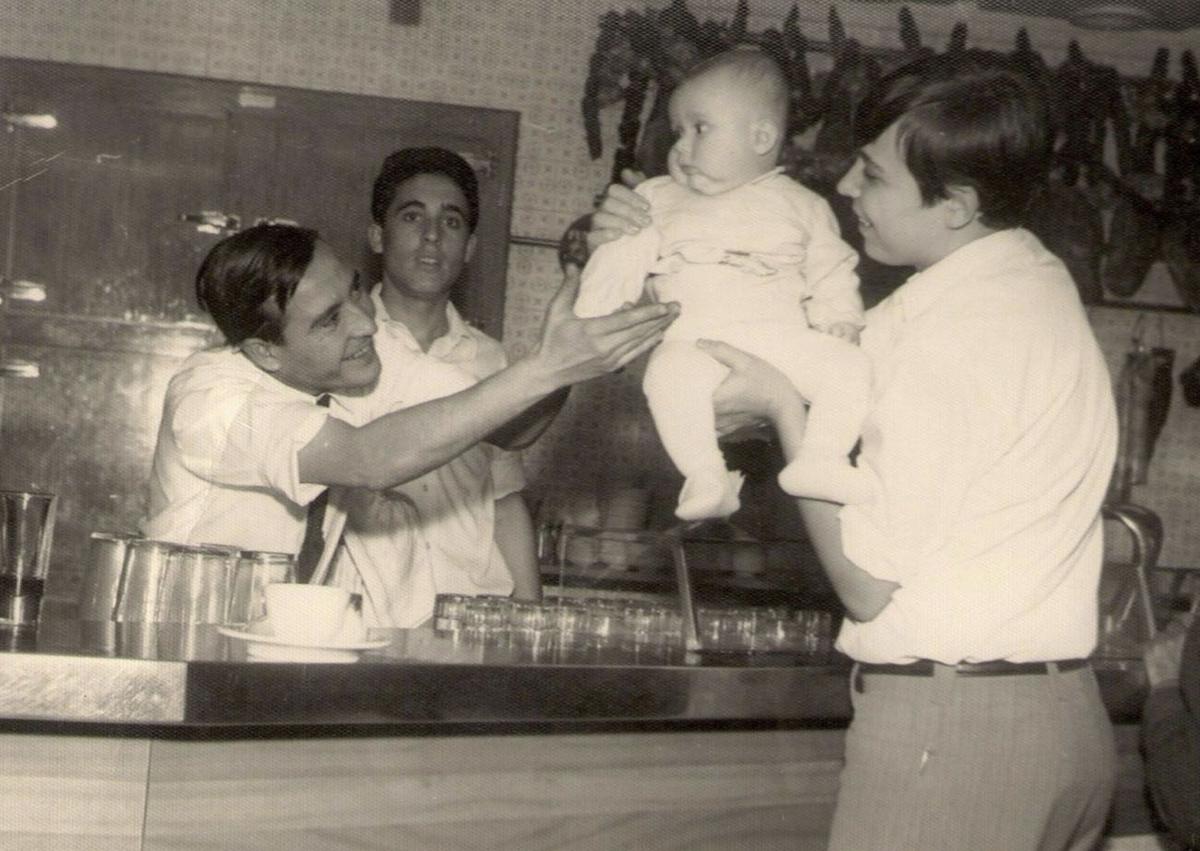 Imagen secundaria 1 - 1. Juanjo Nicolás, de bebé, en brazos de su tío y junto a dos camareros. 2. El matrimonio, hace casi medio siglo, presumiendo de producto. 