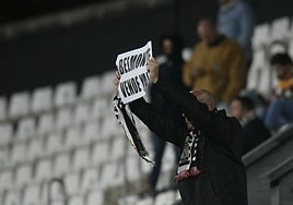Pencho Angosto, presidente de la peña Efesé, muestra un cartel pidiendo la venta del club en el partido ante el Eibar, el 28 de febrero.