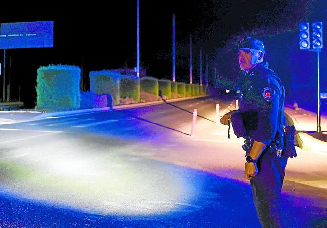 Un policía local dirige el tráfico en Murcia, a oscuras.