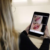Una joven consulta el anuncio de una clínica de medicina estética.