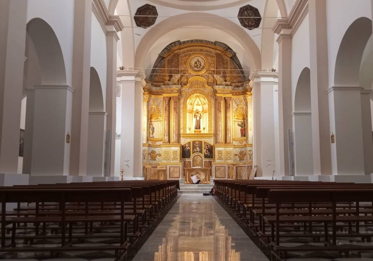 Una restauradora da los últimos retoques a la mesa del altar mayor.