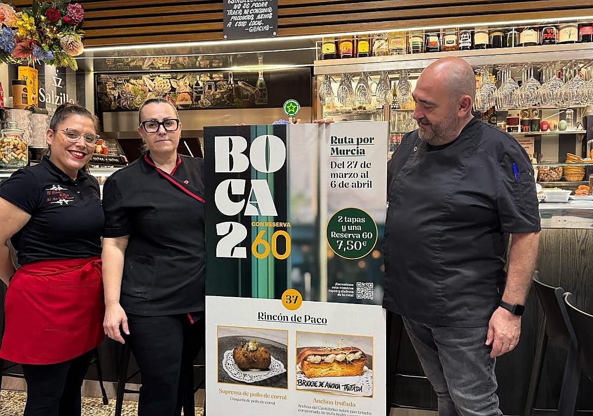 Trabajadores del Rincón de Paco posan junto a las fotos de sus tapas premiadas.