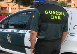 Imagen de archivo de un agente de la Guardia Civil junto a su vehículo.