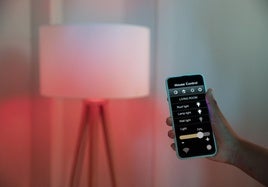 Una persona controla la iluminación de una habitación desde el teléfono móvil.