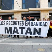 Vecinos del barrio de San Cristóbal tras la pancarta en el centro de salud de San Diego, ayer.
