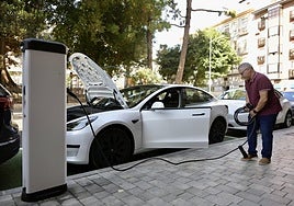 Un propietario de un vehículo eléctrico de batería (BEV) se prepara para cargarlo en la calle.