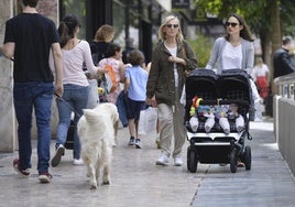 Una madre pasea a sus bebés por una avenida de la ciudad de Murcia.