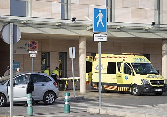 Dos sanitarios suben una camilla a una ambulancia frente a Urgencias del Santa Lucía.