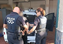 Dos agentes de la Policía Local de Murcia, trasladan al menor detenido.