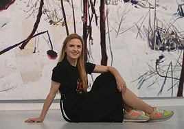 Tatiana Abellán, colaboradora de la edición dominical de LA VERDAD, posa delante de una de las obras de la exposición 'Llueve fuego' de Manuel Pérez en el Centro Párraga de Murcia.