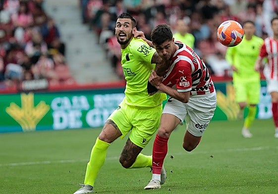 Álex Millán, que firmó una actuación muy pobre, pelea con el central local Diego Sánchez.