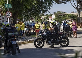 Dos policías locales vigilan a un grupo de vecinos en el acceso a Villas Caravaning, ayer.