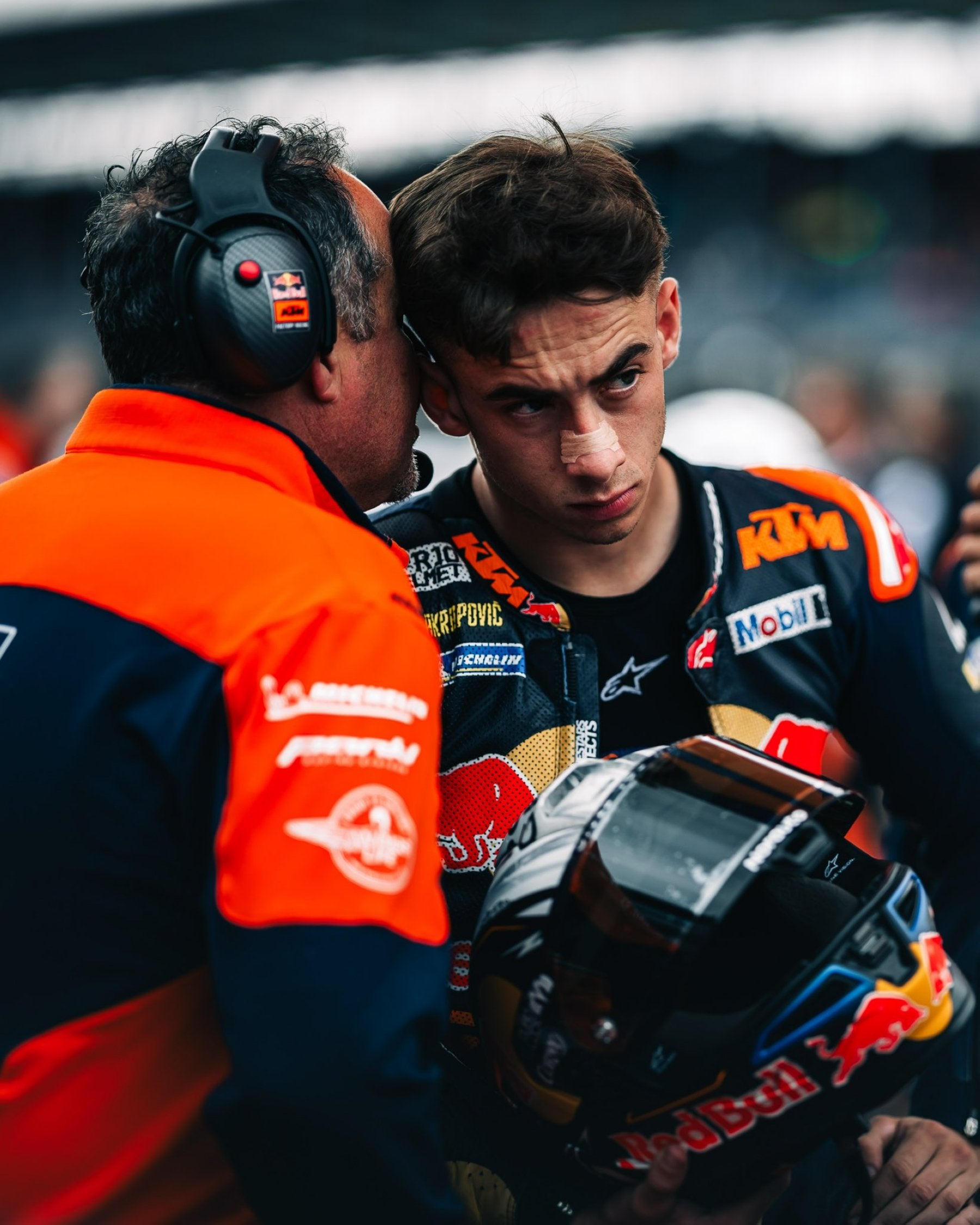 Un miembro del equipo de KTM da indicaciones a Pedro Acosta antes del Gran Premio de Silverstone.