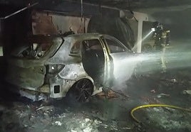 Los bomberos trabajando, este martes, en el concesionario.