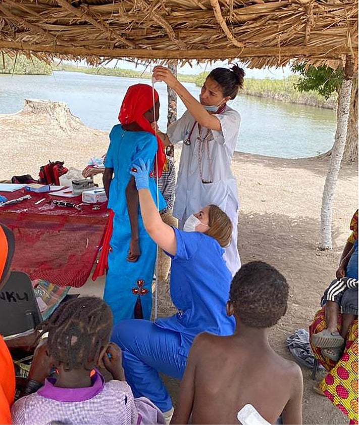 Imagen secundaria 2 - En la primera foto, madres aguardan con sus hijos su turno para ser atendidos en Faji Kunda, Gambia, en 2023. En la segunda imagen, el equipo de Pediatría Solidaria en 2024, en uno de sus trayectos en el país africano. En la tercera, las pediatras Laura Sanz y Ana Jaén atienden a una paciente en el consultorio rural de Kandong.