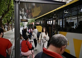 Ciudadanos esperan el autobús en una parada del centro de Murcia.