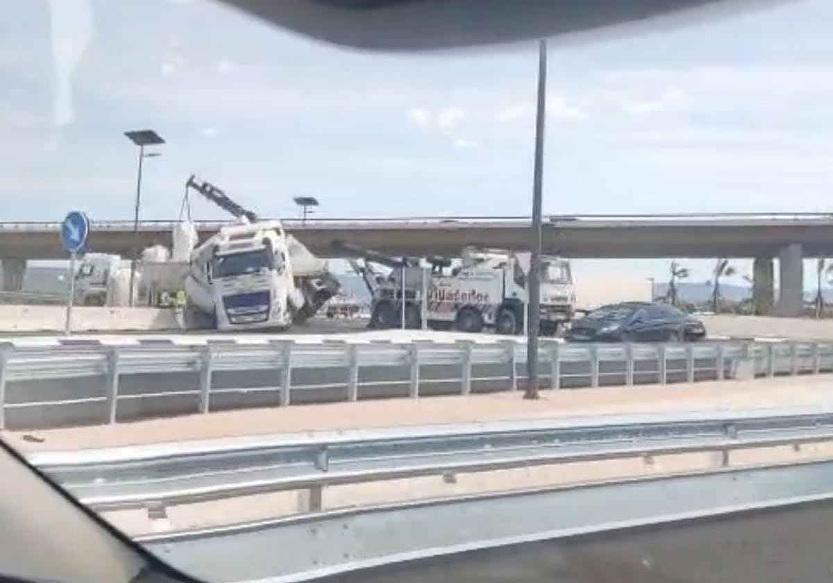 El camión, accidentado, en la rotonda de salida de la autovía A-7.