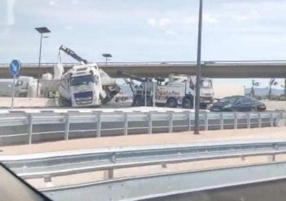 El camión, accidentado, en la rotonda de salida de la autovía A-7.