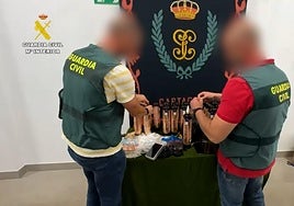 Dos agentes supervisan los objetos incautados.