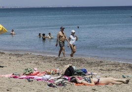 Una mujer tomando el sol en la playa, en una imagen de archivo.