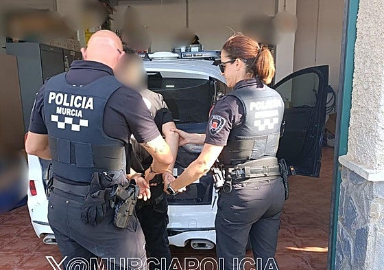 Dos agentes de la Policía Local de Murcia trasladan al detenido.