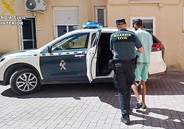 Un agente escolta al detenido por los robos en vehículos en Campos del Río.