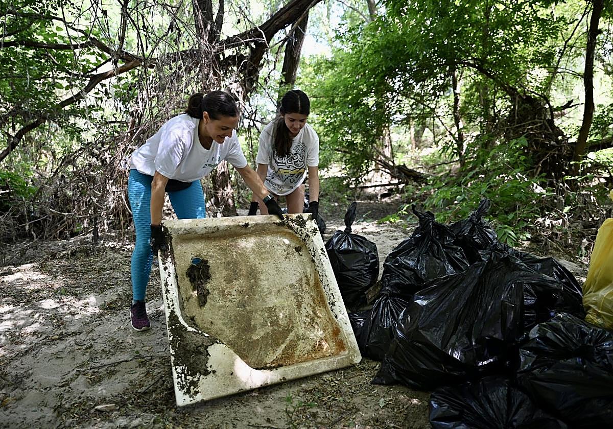 Dos voluntarias retiran un plato de ducha.