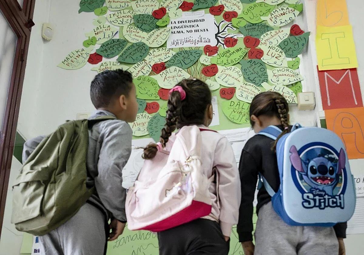 Tres escolares del colegio Santa Rosa de Lima de El Palmar, en Murcia, miran un mural sobre la diversidad lingüística en una imagen de archivo.