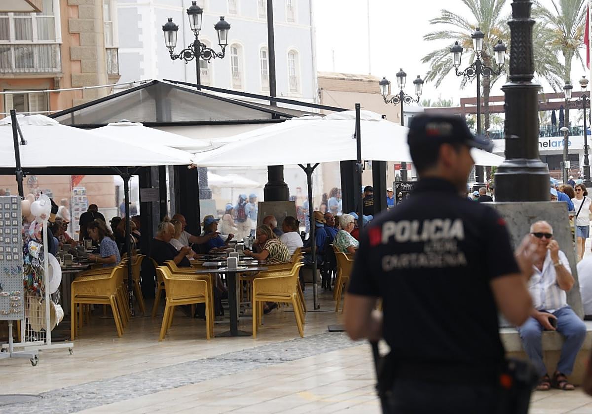 Un agente de la Policía Local patrulla por la calle Mayor, frente a una de las terrazas de la plaza del Ayuntamiento.
