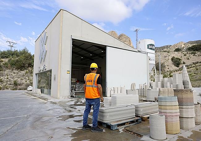 Trabajador de Cementos La Cruz junto a piezas impresas en 3D.