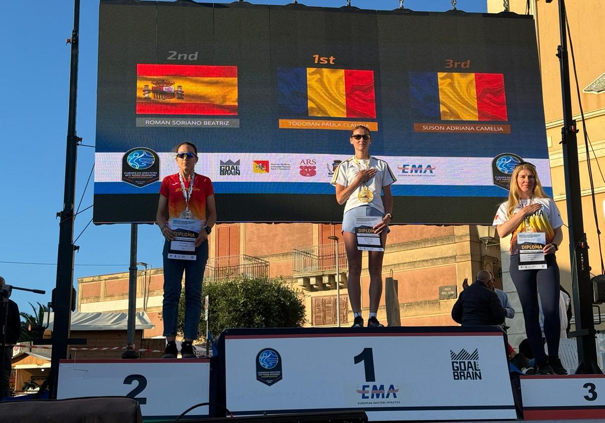 Beatriz Román (i), en el podio con la medalla de plata conseguida en el Europeo Máster Of-Road de Catania.