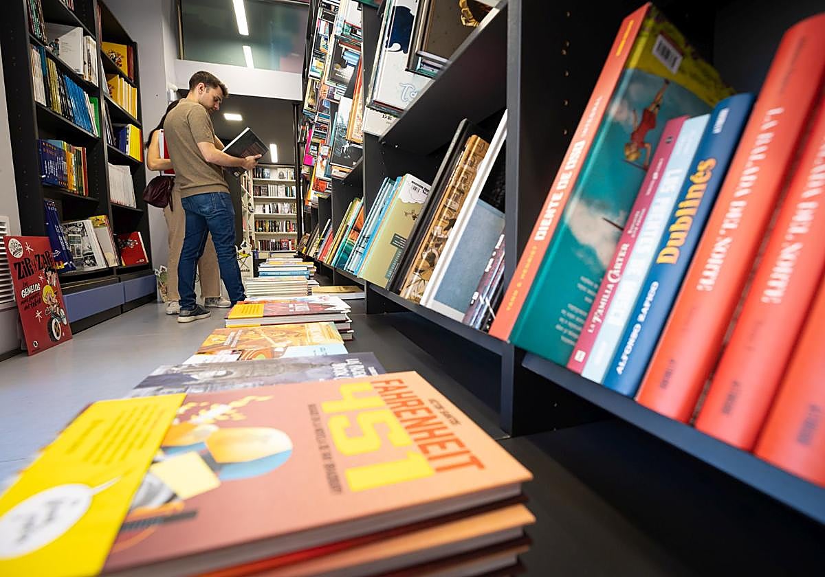 Un joven revisa varios ejemplares en una librería.