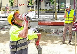Un trabajador de la construcción bebe agua para hidratarse mientras trabaja, en una imagen de archivo.