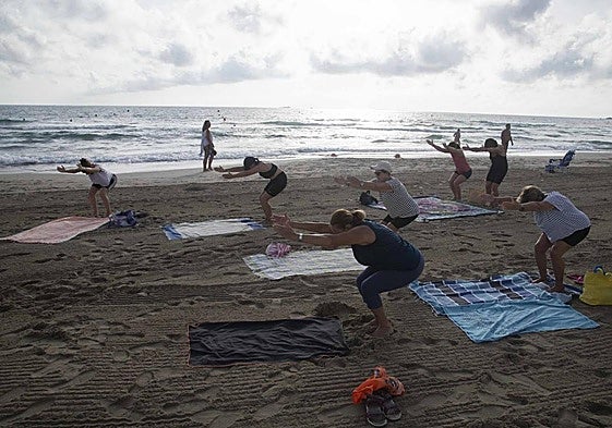 Imagen de archivo de unas mujeres practicando yoga en la playa.